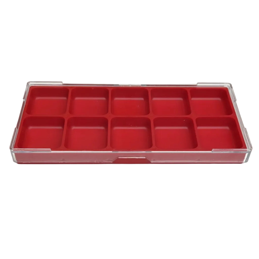 A red plastic organizer tray with multiple small compartments, placed on a white tabletop.
